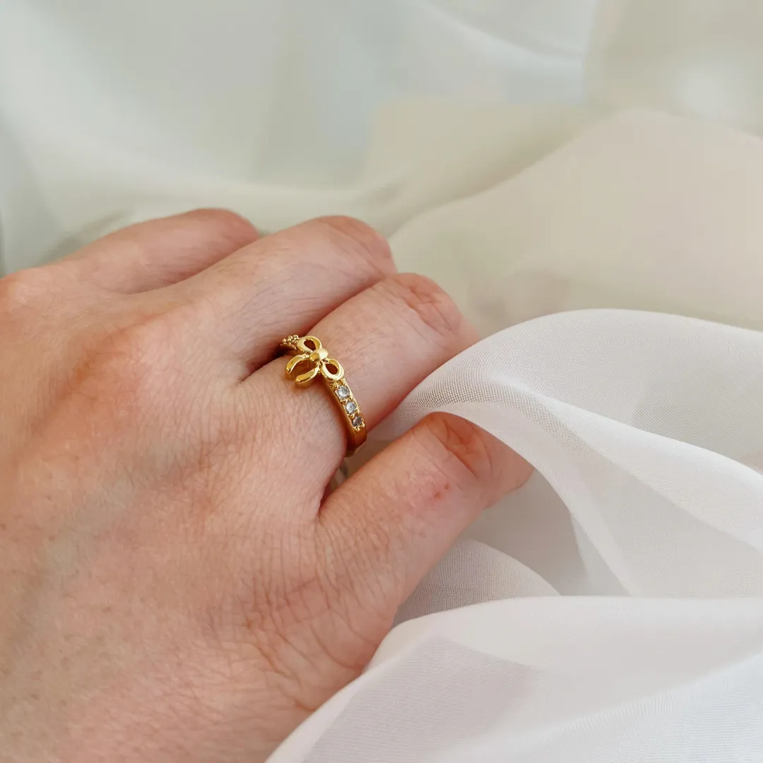 ANEL LAÇO COM MEIO ARO CRAVEJADO. TAMANHO 14. BANHADO A OURO 18K.