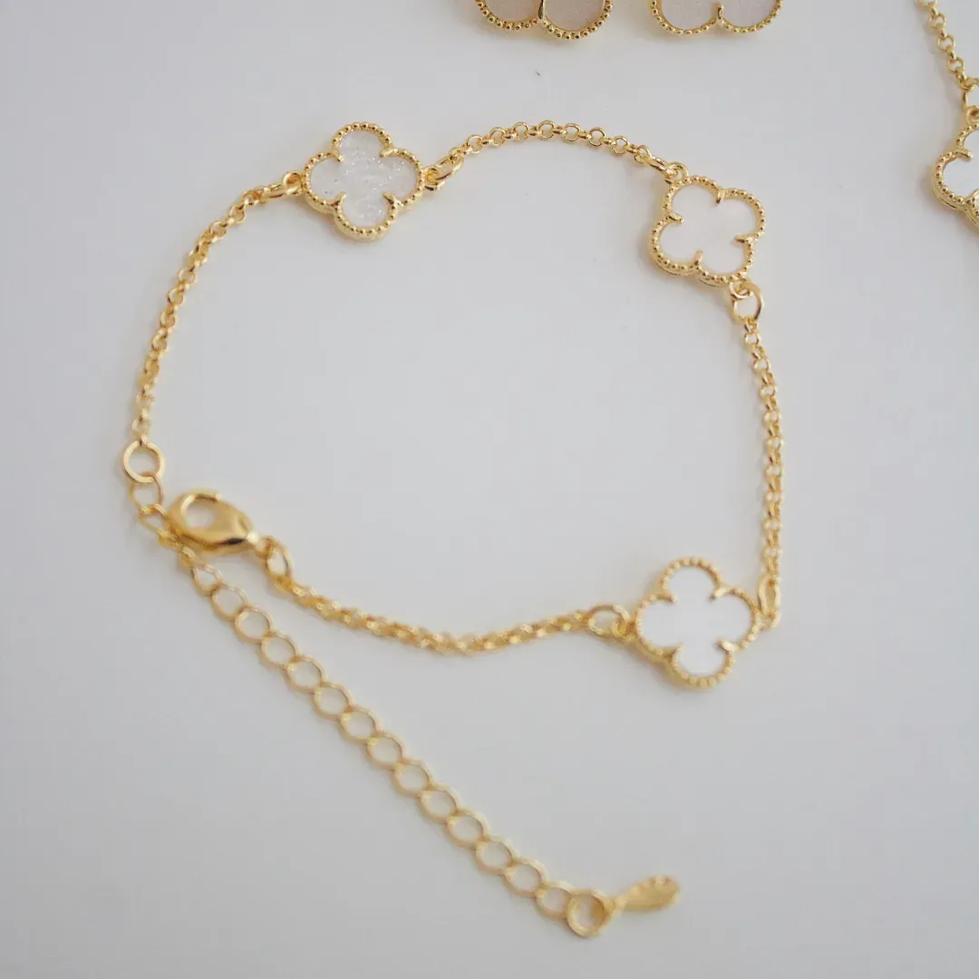 PULSEIRA TREVO MADREPÉROLA. 16CM DE COMPRIMENTO E 5CM DE REGULAGEM. BANHADA A OURO 18K.