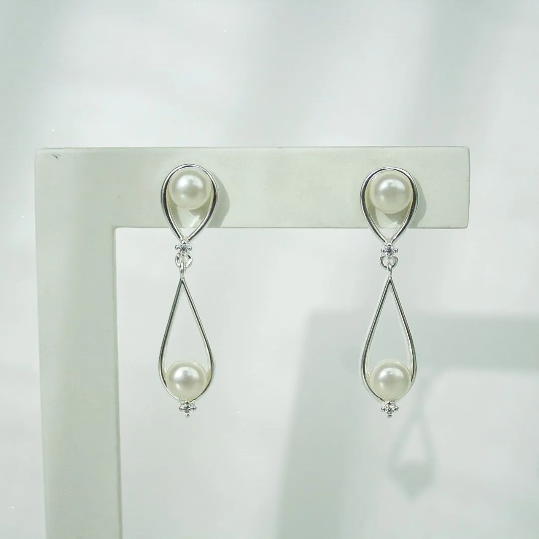 BRINCO 2 GOTAS VAZADA COM PÉROLAS. BANHADA A PRATA.