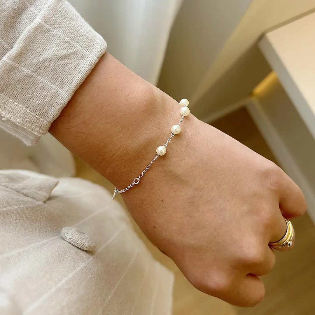 PULSEIRA PÉROLAS COM CRUZ, ESPÍRITO SANTO E MEDALHA DE SÃO BENTO. 18CM DE COMPRIMENTO E 2CM DE REGULAGEM. EM PRATA 925.