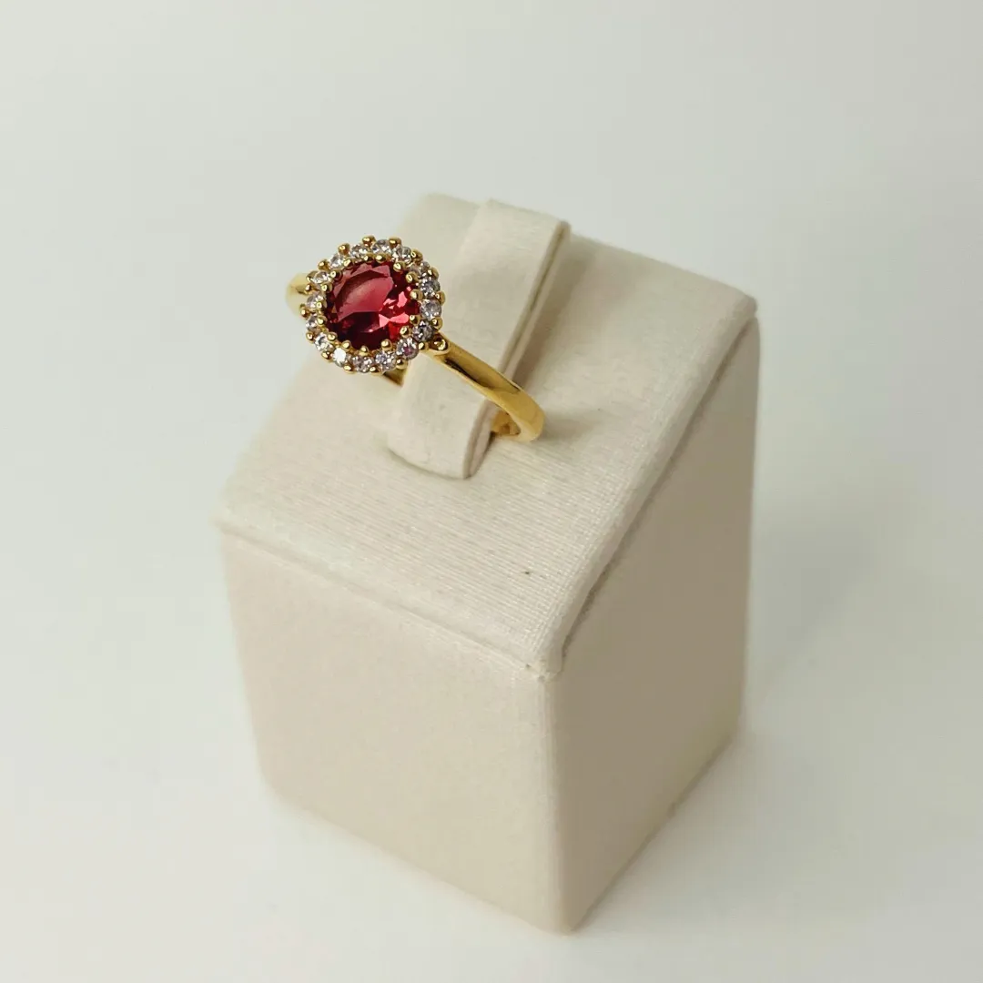 ANEL COM PEDRA RUBI E BORDA CRAVEJADA EM ZIRCÔNIAS. BANHADO A OURO 18K.
