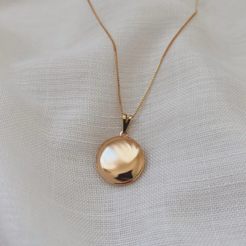 COLAR RELICÁRIO REDONDO LISO 2CM DOURADO. 45CM DE COMPRIMENTO E 5CM DE REGULAGEM. BANHADO A OURO 18K.