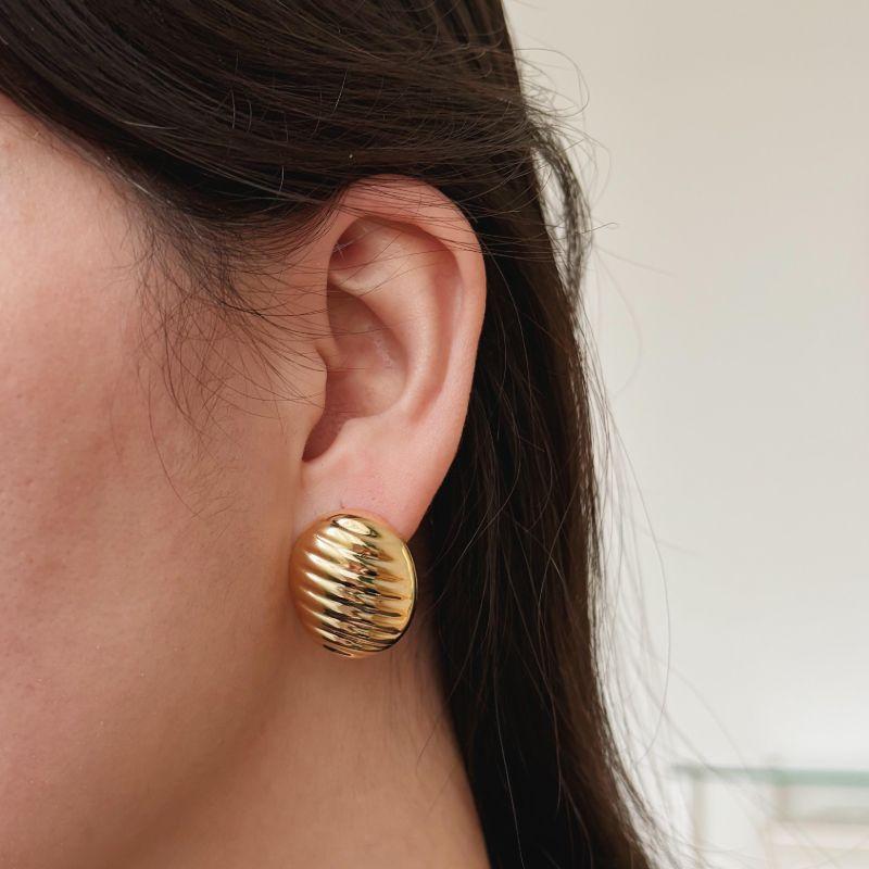 BRINCO MEIA ESFERA OVAL TEXTURIZADA . BANHADO A OURO 18K.