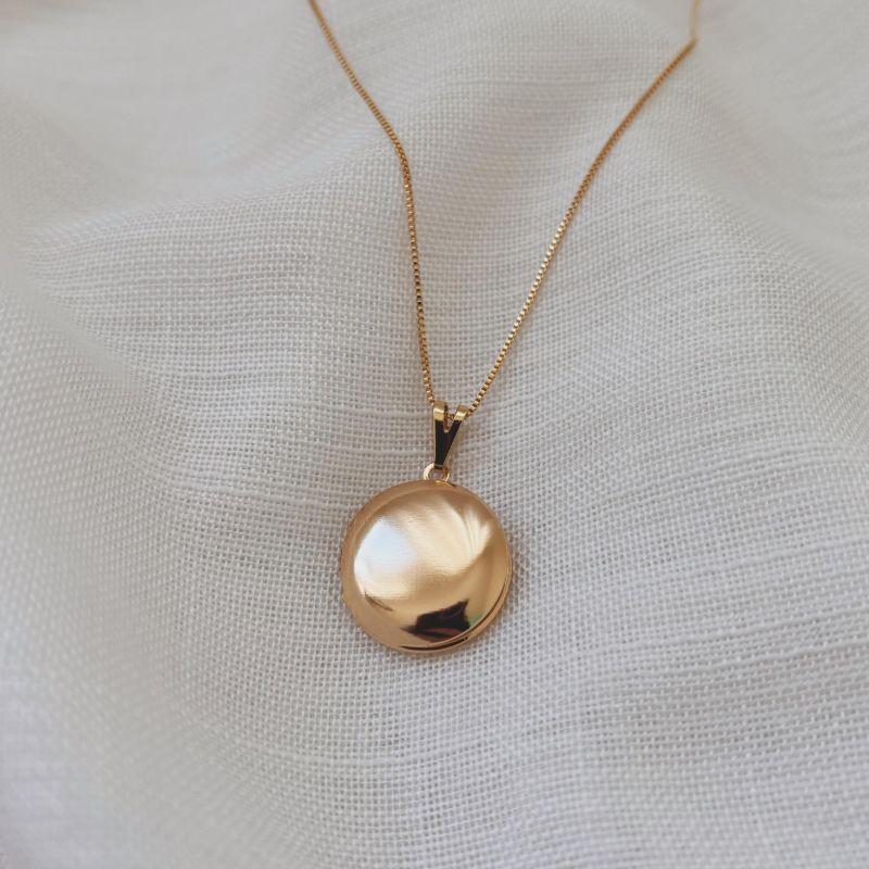 COLAR RELICÁRIO REDONDO LISO 2CM DOURADO. 45CM DE COMPRIMENTO E 5CM DE REGULAGEM. BANHADO A OURO 18K.