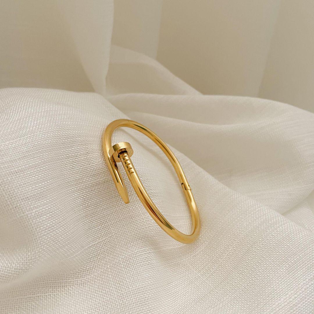 PULSEIRA BRACELETE PREGO. 6CM DE DIÂMETRO. EM AÇO INOX DOURADO.